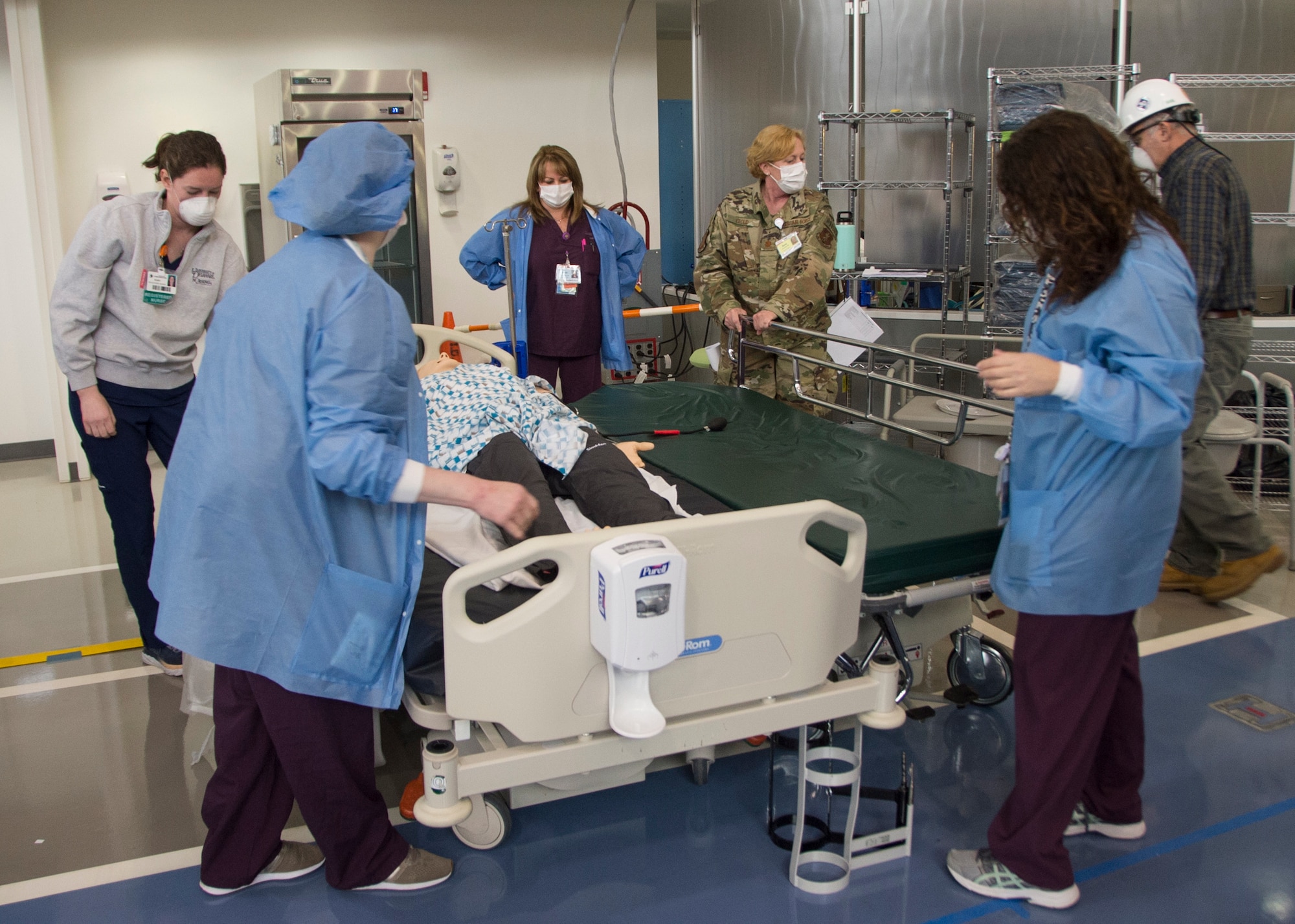 U.S. Air Force Maj. Annie Cloud, 142nd Aeromedical Evacuation Squadron flight nurse simulates the transportation of patients with the medical staff from Nemours/Alfred I. DuPont Hospital for Children, Christiana Care at an alternate care site at A.I. DuPont Hospital, Wilmington, Del., April 7, 2020. The alternative care site will be used to treat adults who are in stable condition who do not have coronavirus and the site will only be used if Delaware hospitals reach capacity. (U.S. Air National Guard Photo by Staff Sgt. Katherine Miller)