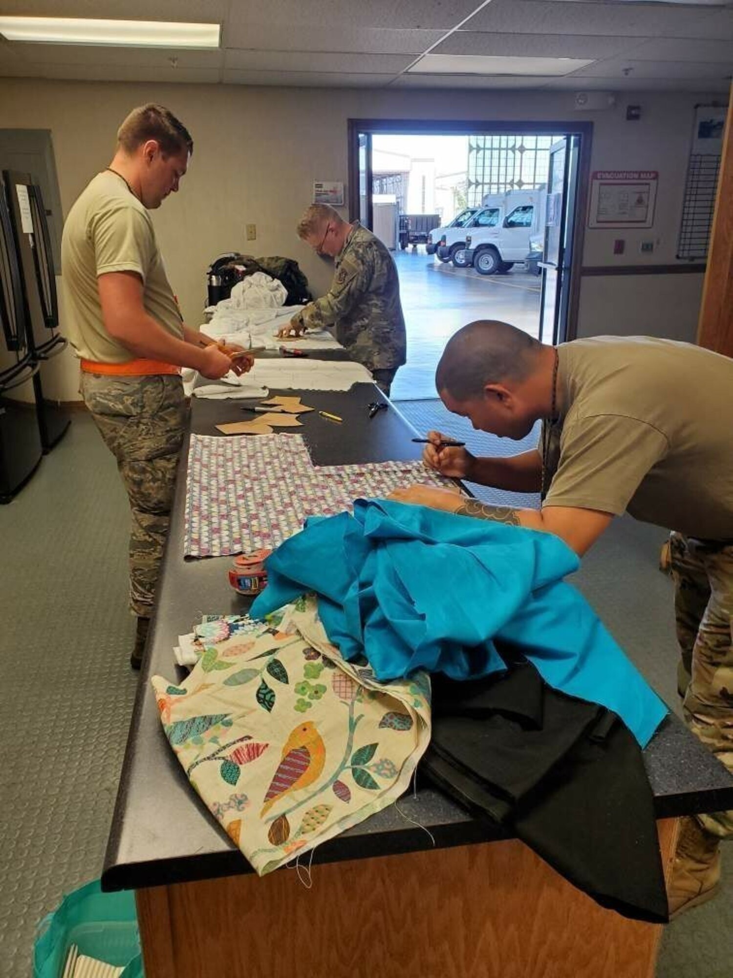 Airmen from the 735th Air Mobility Squadron prepare materials for face masks in response to COVID-19 at Joint Base Pearl Harbor-Hickam, Hawaii. The Airmen hosted a food drive, but their desire to do more resulted in creating face masks in response to the shortage of medical supplies due to the COVID-19 pandemic