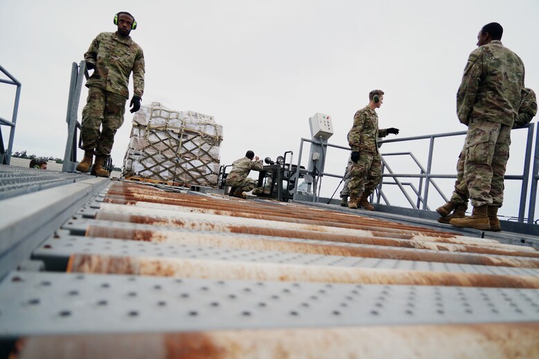 U.S. Air Force 735th Air Mobility Squadron air freight Airmen move cargo from a Tunner 60K  to the docking station at Joint Base Pearl Harbor-Hickam, Hawaii, March 31, 2020. The 735th AMS is  supporting the Indo-Pacific region during the COVID-19 pandemic by transporting supplies to those in need. (U.S. Air Force photo by Airman 1st Class Erin Baxter)