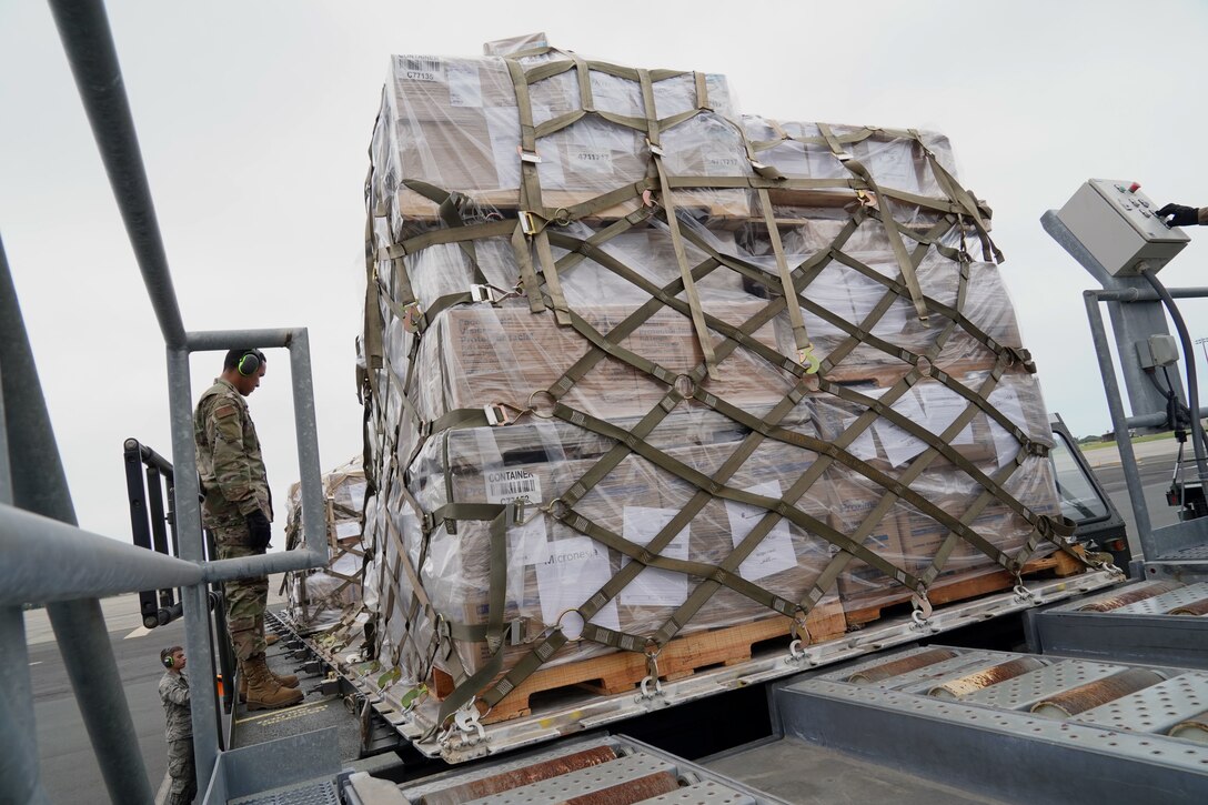 U.S. Air Force Senior Airman Mario Garcia, 735th Air Mobility Squadron air freight journeyman, drives a Tunner 60K loader with cargo from an U.S. Air Force C-17 at Joint Base Pearl Harbor-Hickam, Hawaii, March 31, 2020. The 735th AMS  supports the Indo-Pacific region during the COVID-19 pandemic by transporting supplies to those in need. (U.S. Air Force photo by Airman 1st Class Erin Baxter)