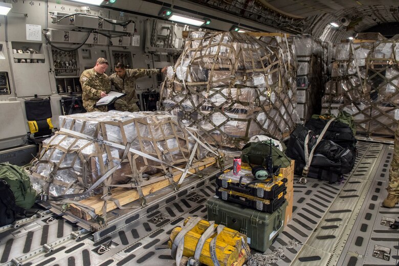U.S. Air Force Airmen and civilians assigned to the 735th Air Mobility Squadron, load 31,063 pounds of cargo containing COVID-19 personal protective equipment and medical supplies at Joint Base Pearl Harbor-Hickam, Hawaii, April  3, 2020. The 735th AMS provided support to the Mariana Islands in response to the COVID-19 pandemic.  (U.S. Air Force photo by Staff. Sgt. Mikaley Kline )