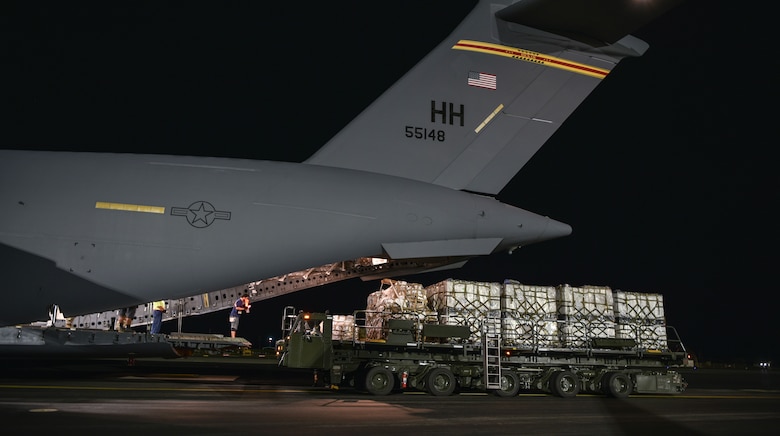 U.S. Air Force Airmen and civilians from the 735th Air Mobility Squadron load COVID-19 personal protective equipment and medical supplies onto a C-17 Globemaster III from the 535th Airlift Squadron at Joint Base Pearl Harbor-Hickam, Hawaii, April  3, 2020. The 735th Air Mobility Squadron loaded 31,063 pounds of cargo containing COVID-19 personal protective equipment and medical supplies from the CDC and FEMA that were delivered to the Mariana Islands.   (U.S. Air Force photo by Tech. Sgt. Anthony Nelson Jr.)