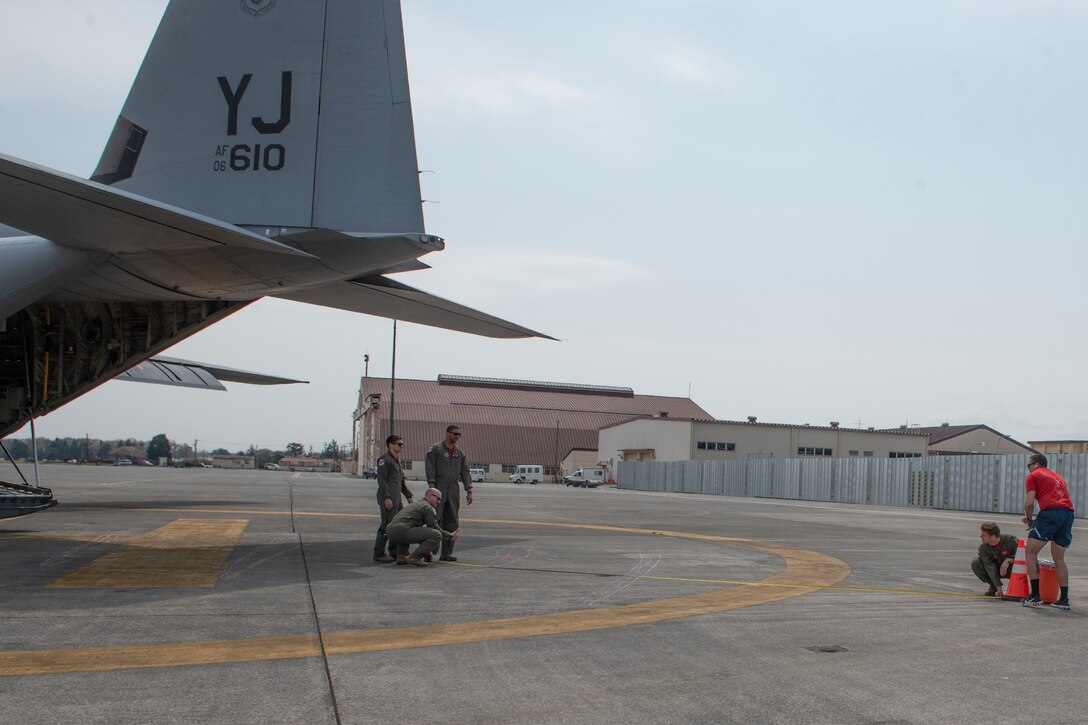 36th Airlift Squadron loadmasters measure the distance of an aircraft tail from a simulated obstacle during the Yokota C‐130J Tactics Rodeo April 3, 2020, at Yokota Air Base, Japan.