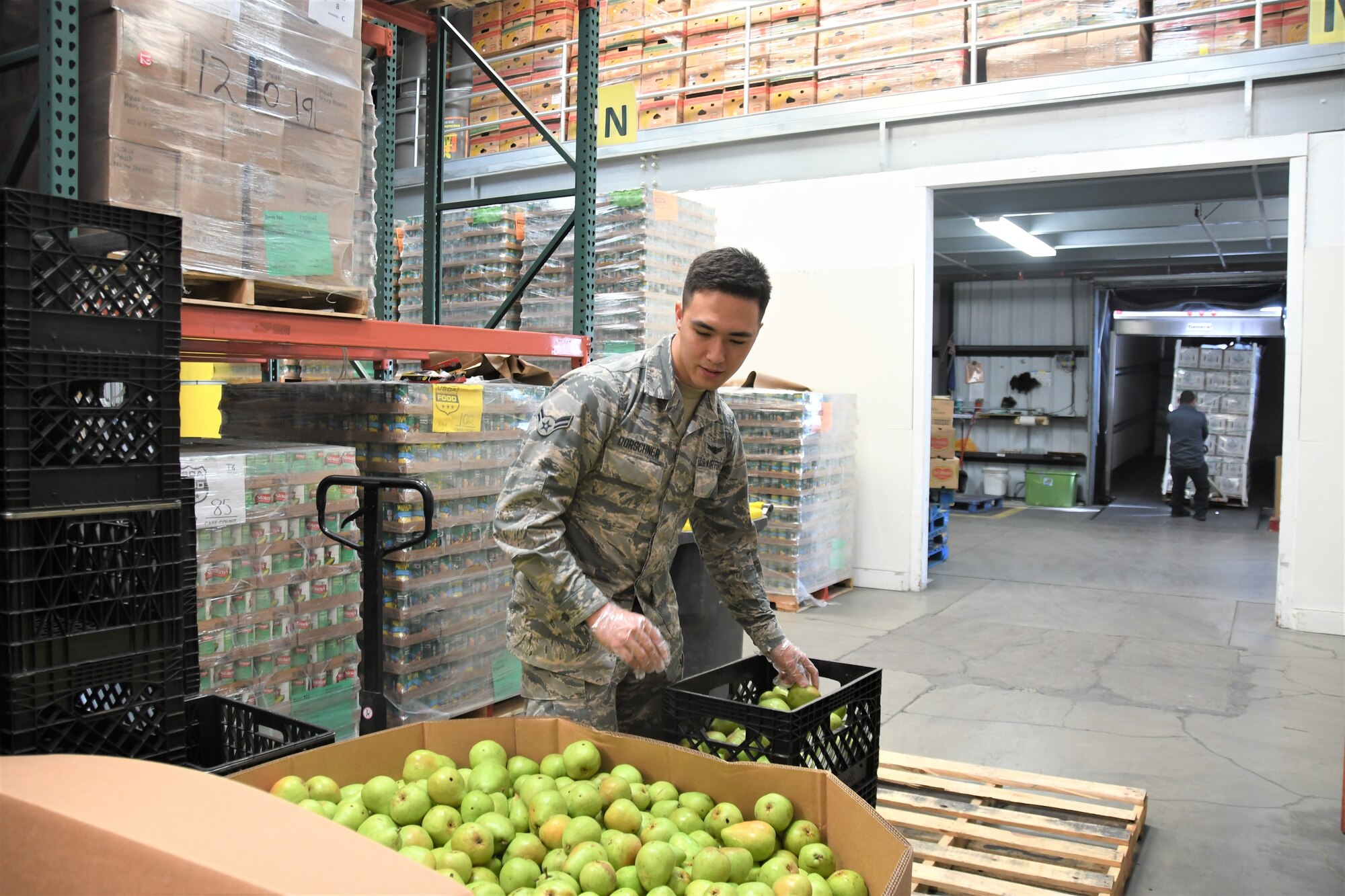 Airman 1st Class Benjamin Dorschner,  a space operator for the California Air National Guard's 216th Space Control Squadron, sorts pears at the Food Bank of Santa Barbara County in Santa Maria, California, on April 2, 2020, as part of the California National Guard's COVID-19 humanitarian mission.