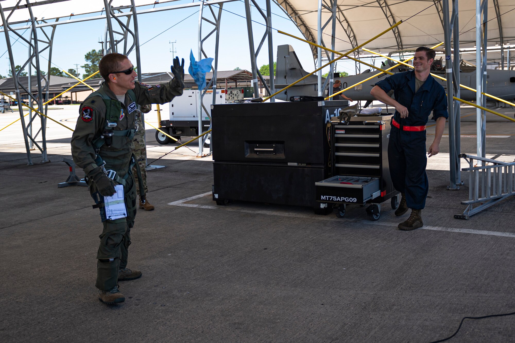 A photo of an Airman throwing a rag to a pilot