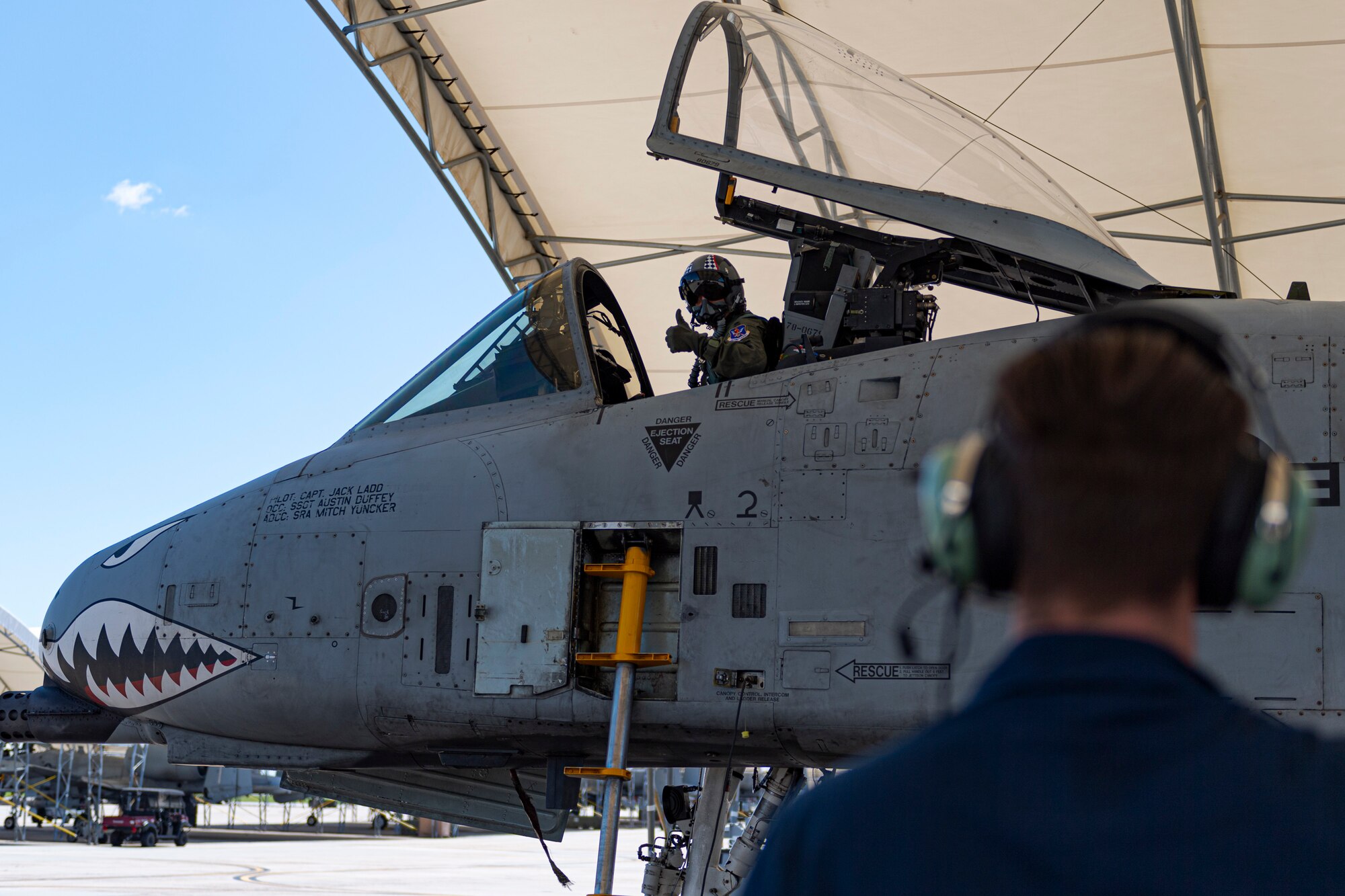 A photo of a pilot giving an Airman a thumbs-up