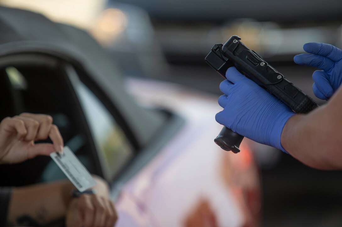 U.S. Marine Lance Cpl. Austin Sawyeron, a military police officer with Provost Marshal’s Office, Security and Emergency Services Battalion, scans an ID card at the San Luis Rey gate on Marine Corps Base Camp Pendleton, California, April 2, 2020.