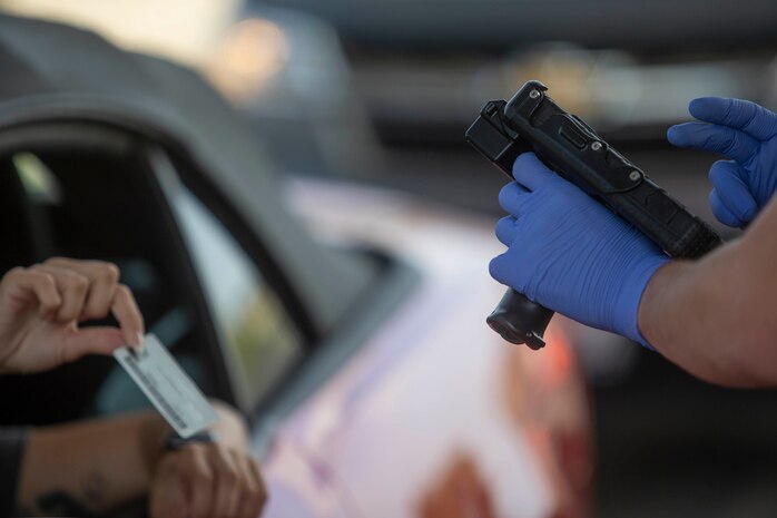 U.S. Marine Lance Cpl. Austin Sawyeron, a military police officer with Provost Marshal’s Office, Security and Emergency Services Battalion, scans an ID card at the San Luis Rey gate on Marine Corps Base Camp Pendleton, California, April 2, 2020.