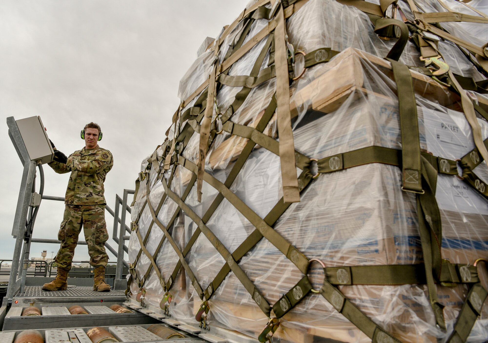 U.S. Air Force Airman Basic Brock Dowell, 735th Air Mobility Squadron air freight apprentice, monitors cargo on a conveyor belt at Joint Base Pearl Harbor-Hickam, Hawaii, March 31, 2020. The 735th AMS ensures incoming aircraft are mission-capable and can leave with cargo and personnel in a timely fashion. (U.S. Air Force photo by Tech. Sgt. Anthony Nelson Jr.)