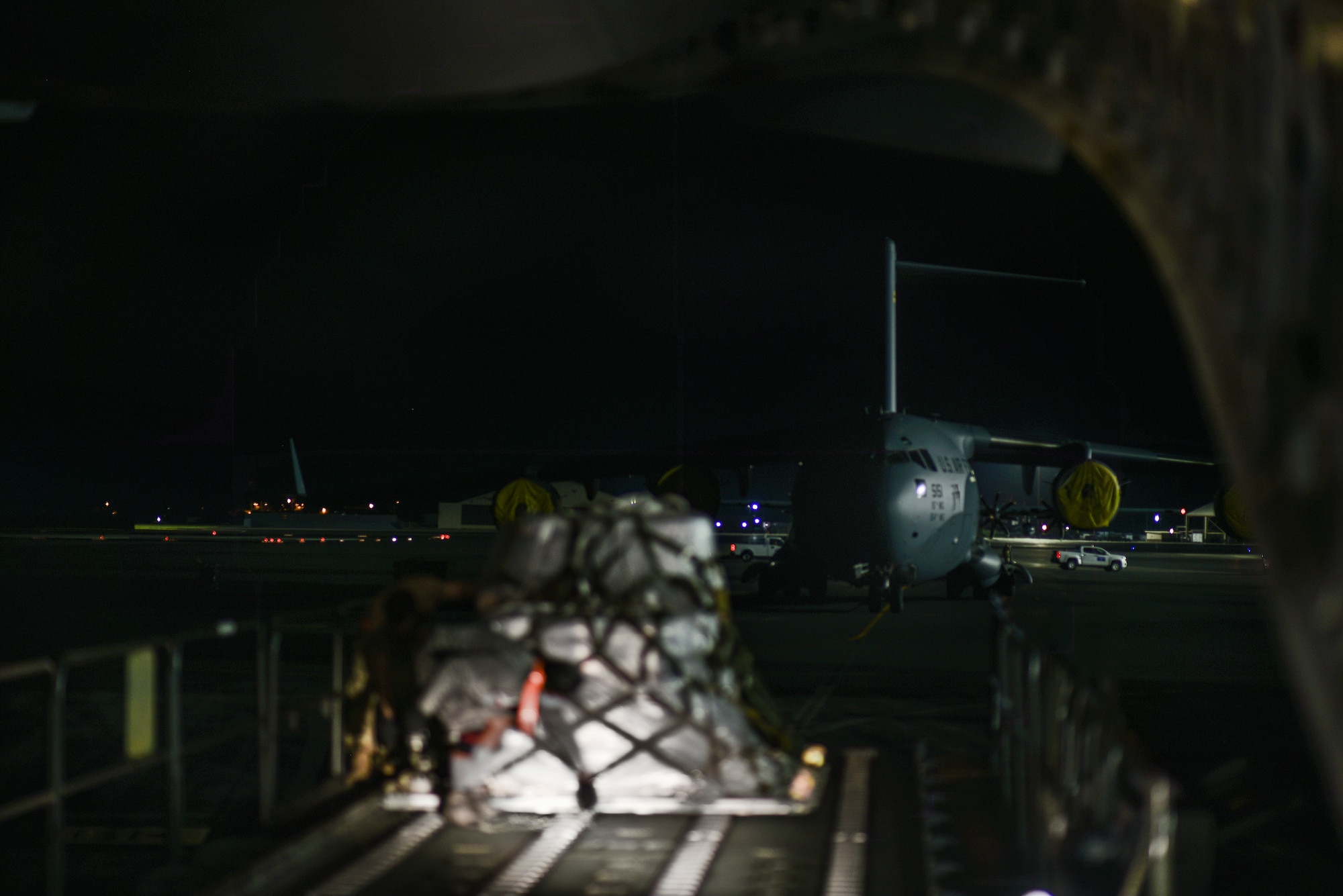 U.S. Air Force Airmen and civilians with the 735th Air Mobility Squadron load COVID-19 personal protective equipment and medical supplies from a Tunner 60K loader onto a C-17 Globemaster III from the 535th Airlift Squadron at Joint Base Pearl Harbor-Hickam, Hawaii, April  3, 2020. With a 72-hour notification, the 735th AMS loaded 31,063 pounds of cargo in support of the COVID-19 response.  (U.S. Air Force photo by Tech. Sgt. Anthony Nelson Jr.)