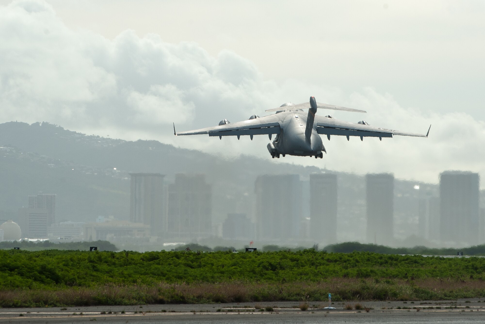 A 535th Airlift Squadron A C-17 Globemaster III takes off from Joint Base Pearl Harbor-Hickam, Hawaii, April  3, 2020.  The 735th Air Mobility Squadron loaded 31,063 pounds of cargo containing COVID-19 personal protective equipment and medical supplies from the CDC and FEMA that were delivered to the Mariana Islands.  (U.S. Air National Guard photo by Senior Airman John Linzmeier)