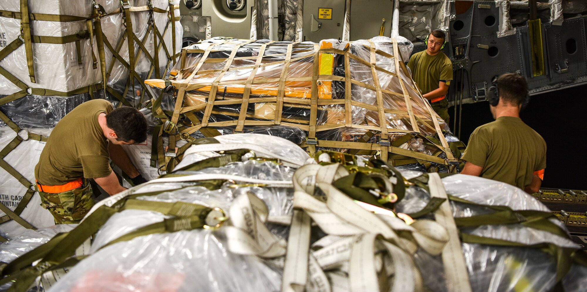 U.S. Air Force Airmen assigned to the 735th Air Mobility Squadron, secure top and side nets of a pallet at Joint Base Pearl Harbor-Hickam, Hawaii, April  3, 2020. With a 72-hour notification, the 735th AMS loaded 31,063 pounds of cargo in support of the COVID-19 response. (U.S. Air Force photo by Tech. Sgt. Anthony Nelson Jr.)