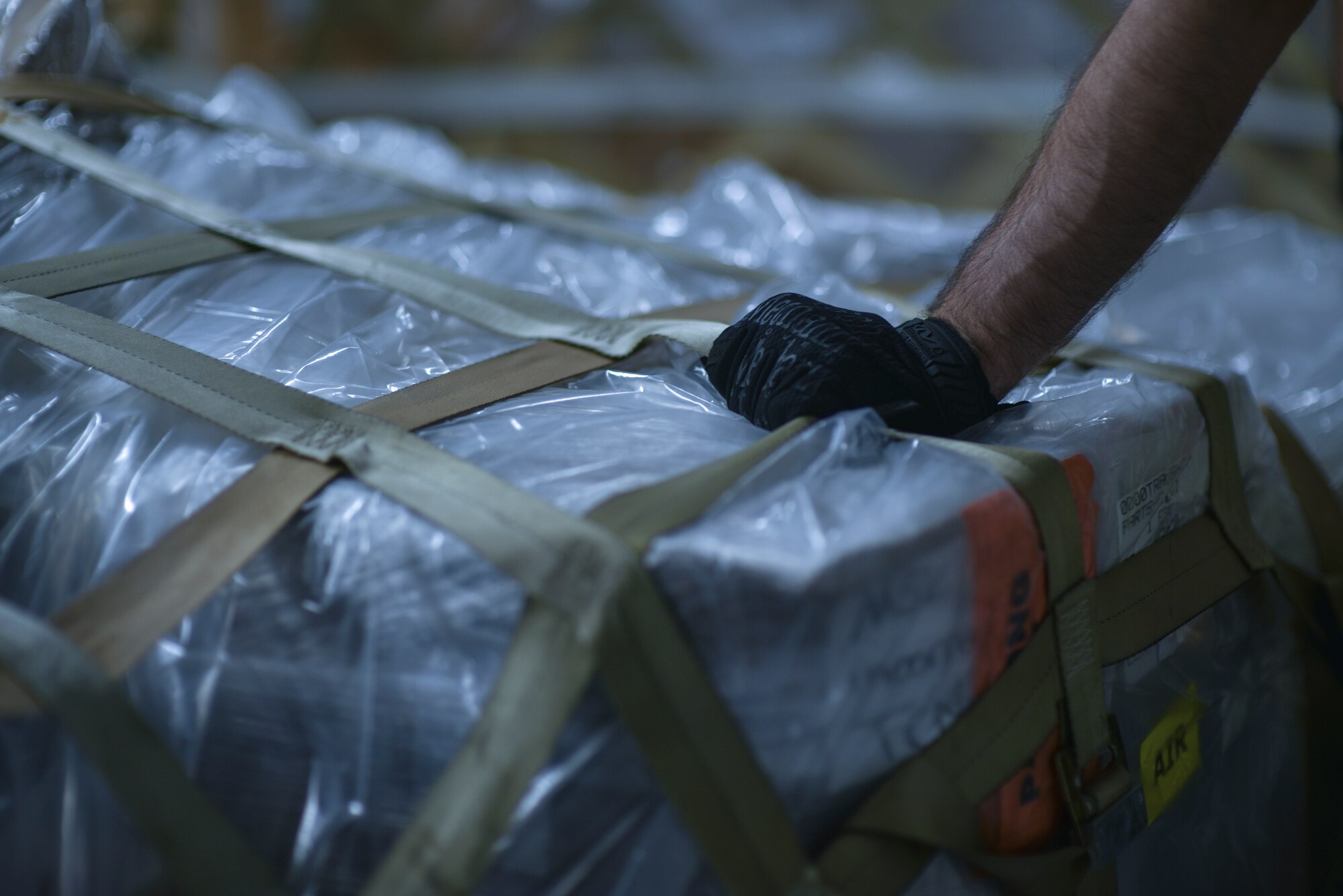 U.S. Air Force Staff Sgt. Charles Brown, 735th Air Mobility Squadron aircraft services supervisor, secures the top net of a COVID-19 pallet containing personal protective equipment and medical supplies on board of a  C-17 Globemaster III from the 535th Airlift Squadron at Joint Base Pearl Harbor-Hickam, Hawaii, April  3, 2020. The 735th AMS provided support to the Mariana Islands in response to the COVID-19 pandemic.  

 (U.S. Air Force photo by Tech. Sgt. Anthony Nelson Jr.)