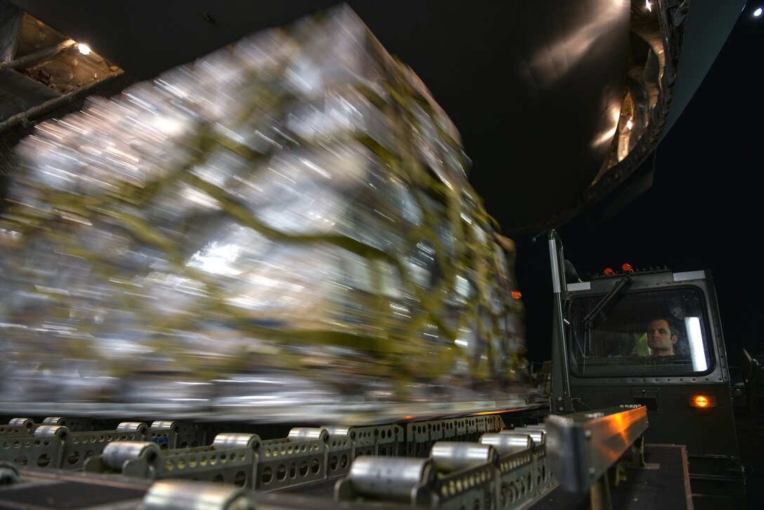 U.S. Air Force Staff Sgt. Charles Brown, 735th Air Mobility Squadron aircraft services supervisor, drives a Tunner 60K loader carrying COVID-19 personal protective equipment and medical supplies at Joint Base Pearl Harbor-Hickam, Hawaii, April  3, 2020. A C-17 Globemaster III from the 535th Airlift Squadron flew to the Mariana Islands in response to the COVID-19 pandemic.   (U.S. Air Force photo by Tech. Sgt. Anthony Nelson Jr.)