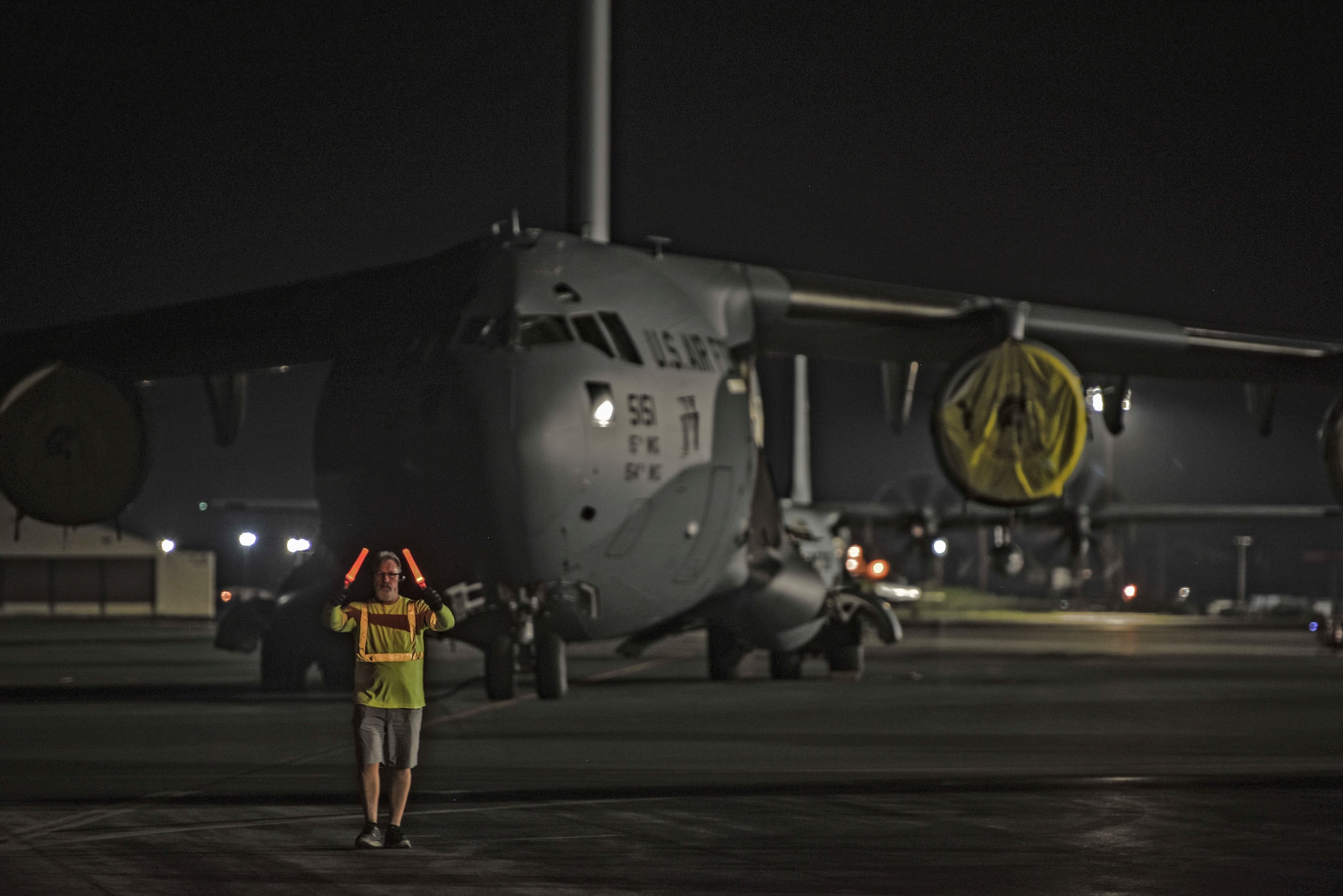 Bruce Miller, 735th Air Mobility Squadron Aircraft loader, spots a Tunner 60K loader driver on the flightline at Joint Base Pearl Harbor-Hickam, Hawaii, April  3, 2020. The 735th Air Mobility Squadron provided support to the Mariana Islands in response to the COVID-19 pandemic.  

 (U.S. Air Force photo by Tech. Sgt. Anthony Nelson Jr.)
