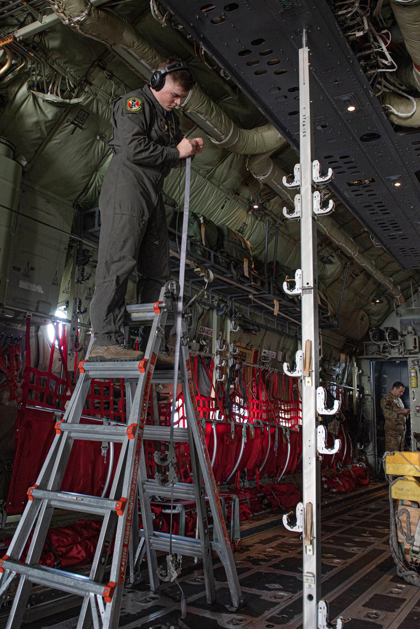Senior Airman Anthony Griffin, 36th Airlift Squadron loadmaster, installs a strap to hold up litters to execute an aeromedical evacuation scenario during the Yokota C‐130J Tactics Rodeo April 3, 2020, at Yokota Air Base, Japan.