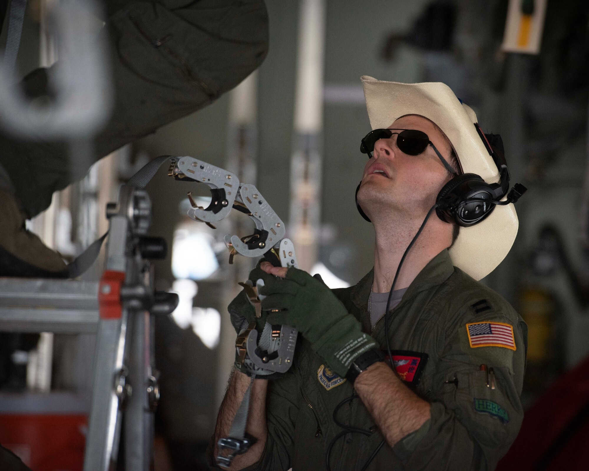 Capt. Devon Alford, 374th Operations Support Squadron tactics officer, helps his teammate install a strap to hold up litters to execute an aeromedical evacuation scenario during the Yokota C‐130J Tactics Rodeo April 3, 2020, at Yokota Air Base, Japan.