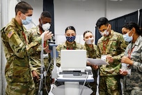 A group of guardsmen test medical equipment at a field medical station.