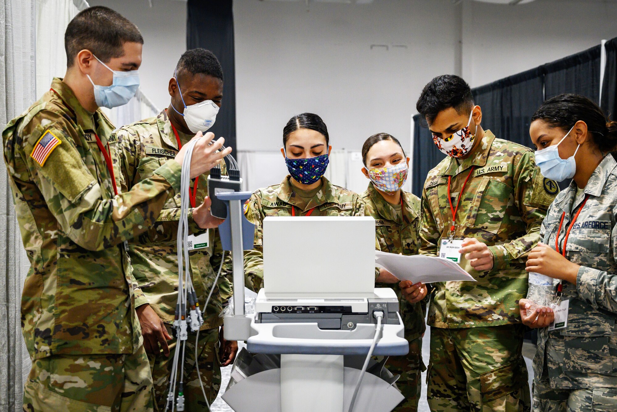 A group of guardsmen test medical equipment at a field medical station.