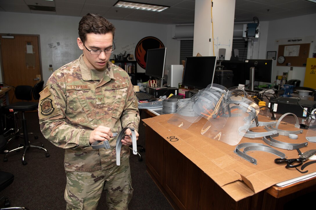 U.S. Air Force Staff. Sgt. Maximilion Estrada, Phoenix Spark noncommissioned officer in charge of agile manufacturing, assembles a face shield, April 6, 2020, at Travis Air Force Base, California. The 60th Air Mobility Wing Phoenix Spark innovation cell has been working with other base organizations, the 60th Aerospace Medicine Squadron bioenvironmental engineering flight and the 60th Maintenance Squadron fabrication flight, since the beginning of March to deliver innovative personal protective equipment to Airmen amidst COVID-19. (U.S. Air Force photo by Senior Airman Jonathon Carnell)