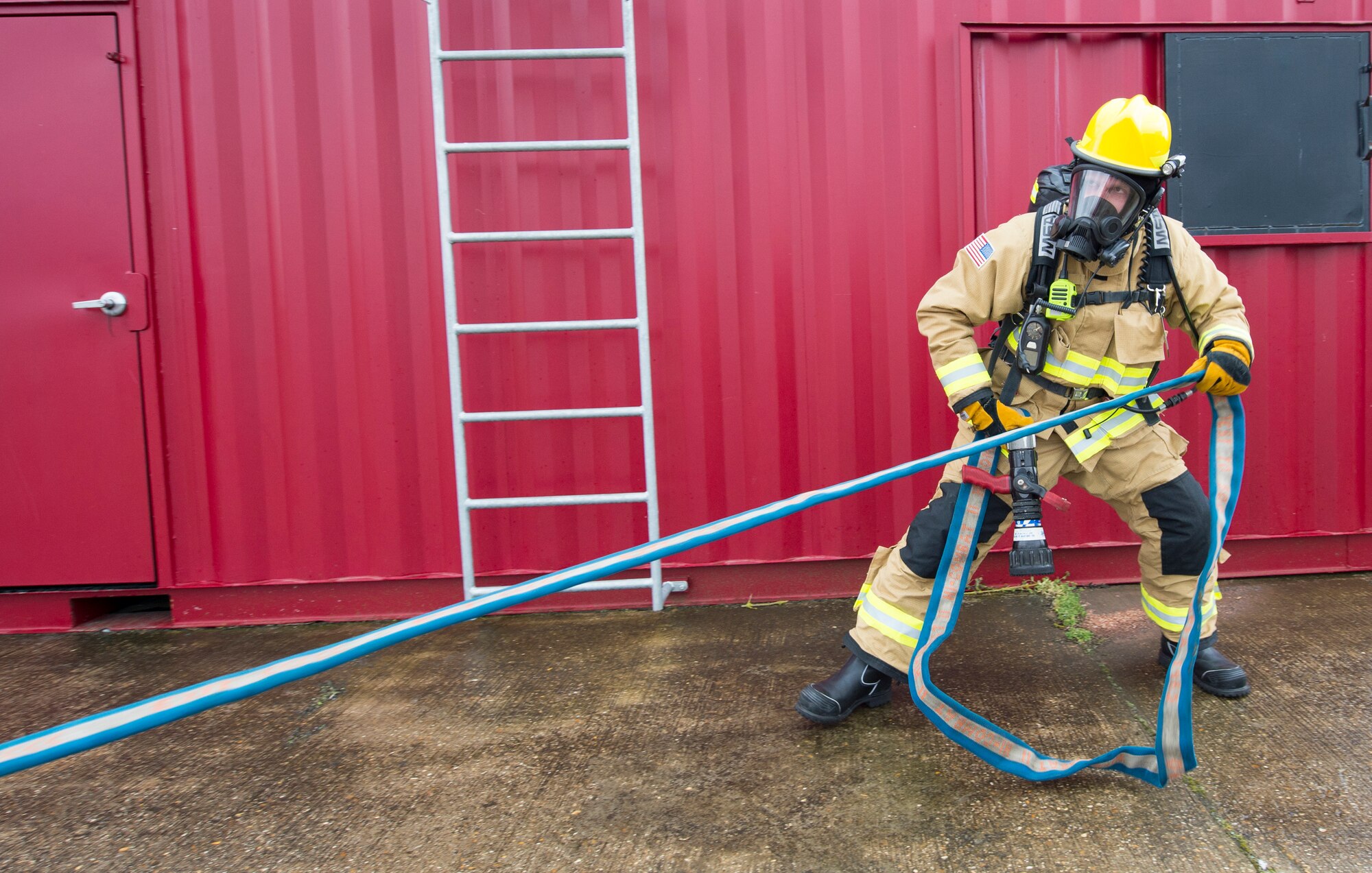 A firefighter with the 423rd Civil Engineer Squadron secures a firehose during confined spaces training at RAF Alconbury, England on March 30, 2020. This type of training helps the firefighters maintain readiness and stay proficient in their craft. (U.S. Air Force photo by Master Sgt. Brian Kimball)