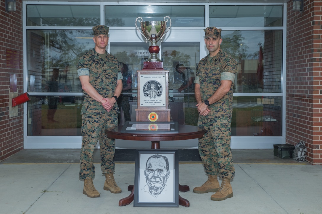 Lt. Col. Thomas Heller (left), the commanding officer of 8th Communication Battalion, II MEF Information Group, and Sgt. Maj. Joyuanki Victore, sergeant major of 8th Comm., pose for a photo beside the “Lieutenant General Chesty Puller Outstanding Leadership Award” (Large Unit Category) trophy and citation at Camp Lejeune, N.C.,