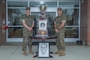Lt. Col. Thomas Heller (left), the Commanding Officer of 8th Communication Battalion, II MEF Information Group, and Sgt. Maj. Joyuanki Victore, sergeant major of 8th Comm., pose for a photo beside the “Lieutenant General Chesty Puller Outstanding Leadership Award” (Large Unit Category) trophy and citation at Camp Lejeune, N.C.,