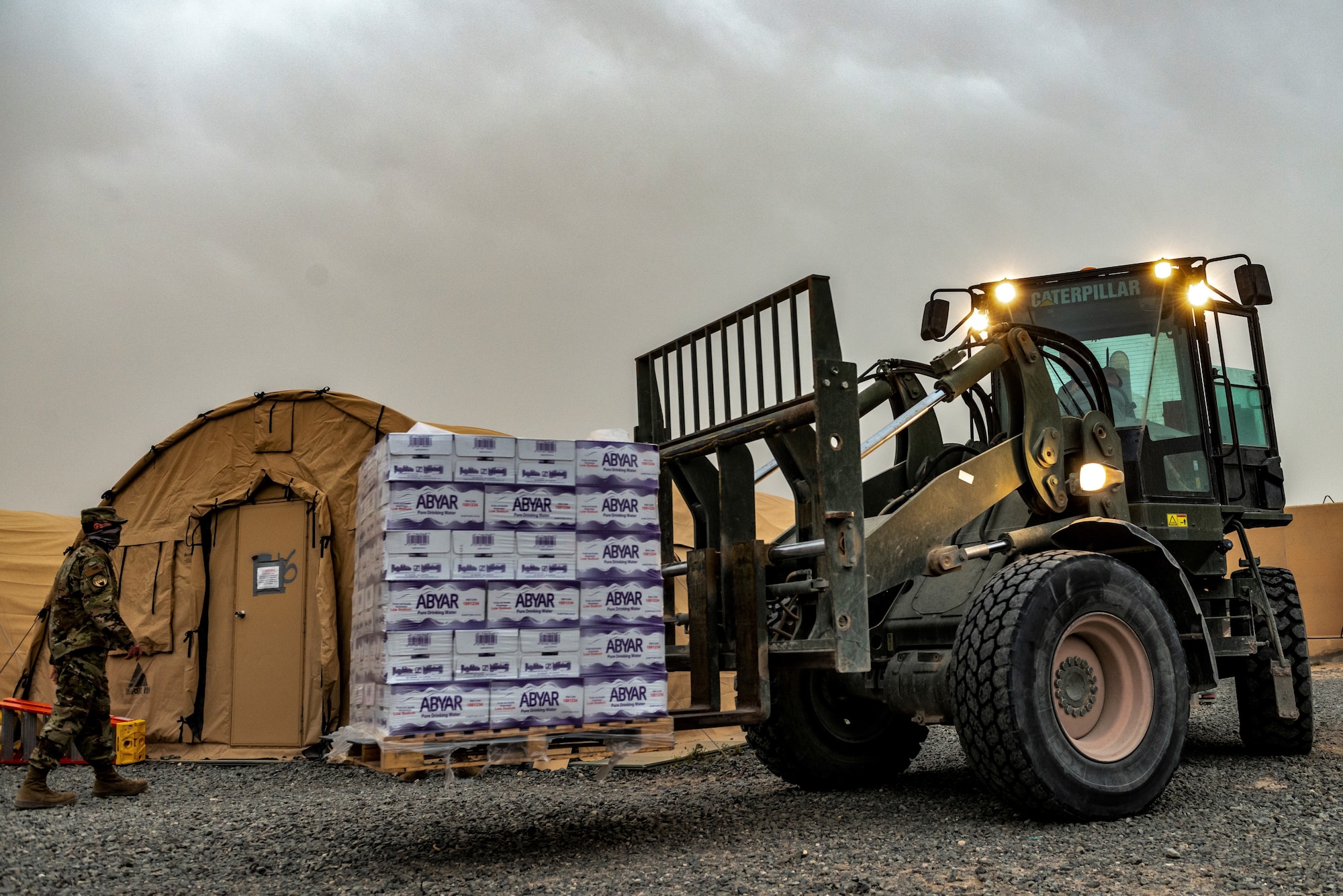 heavy equipment operator transports cases of water