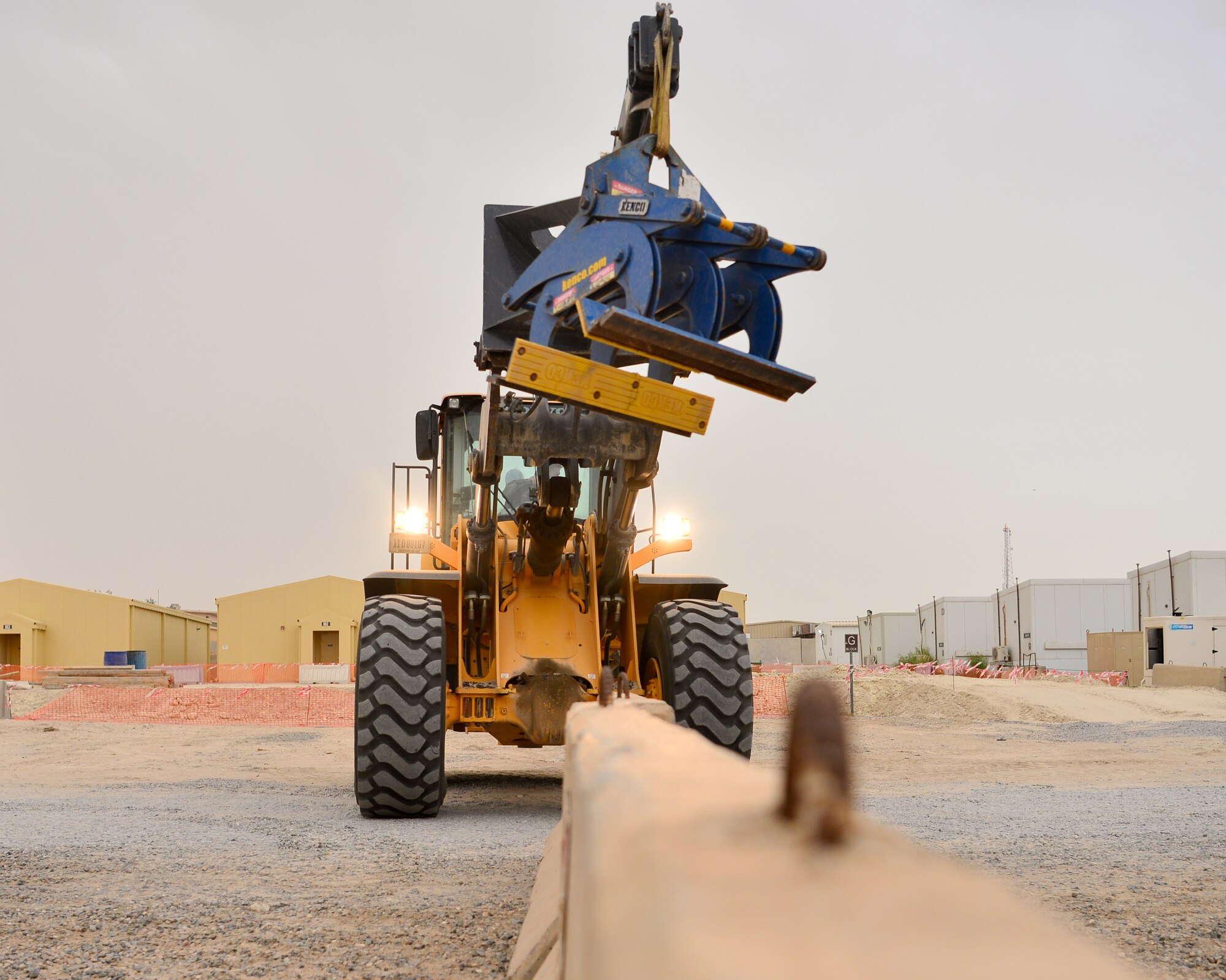 Airman uses heavy equipment to move barriers