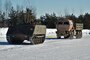 Military vehicles on an icy road.