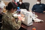 Chief Master Sgt. Tracie Darby, 167th Medical Group superintendent, demonstrates how to make cloth face masks from T-shirts to 167th personnel, April 7, 2020.