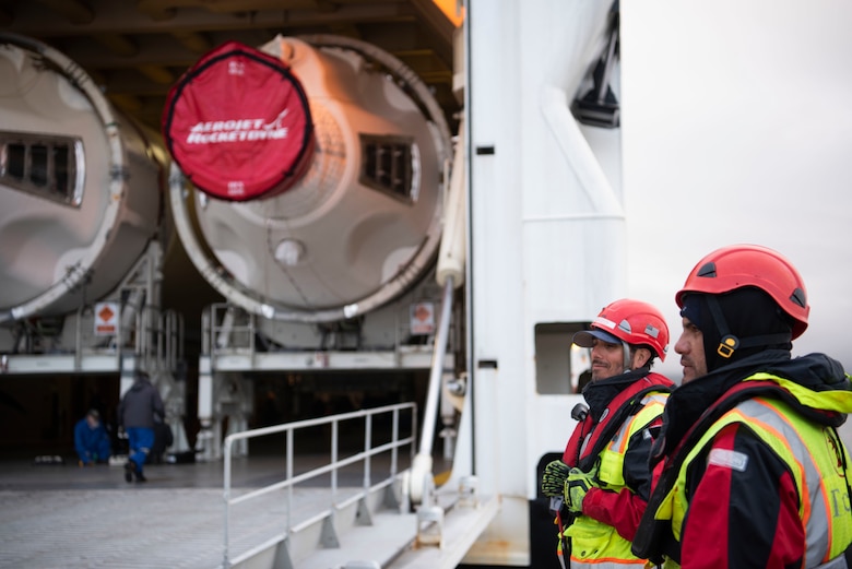 Members of TracTide Marine Corporation prepare to conduct a safety check during an offload of Delta IV Heavy boosters April 5, 2020, at Vandenberg Air Force Base, Calif. The TracTide members are based out of Port Hueneme, Calif., and assisted during the offload of the boosters to ensure the safety of the members and the United Launch Alliance barge, known as the RocketShip. (U.S. Air Force photo by Senior Airman Aubree Owens)
