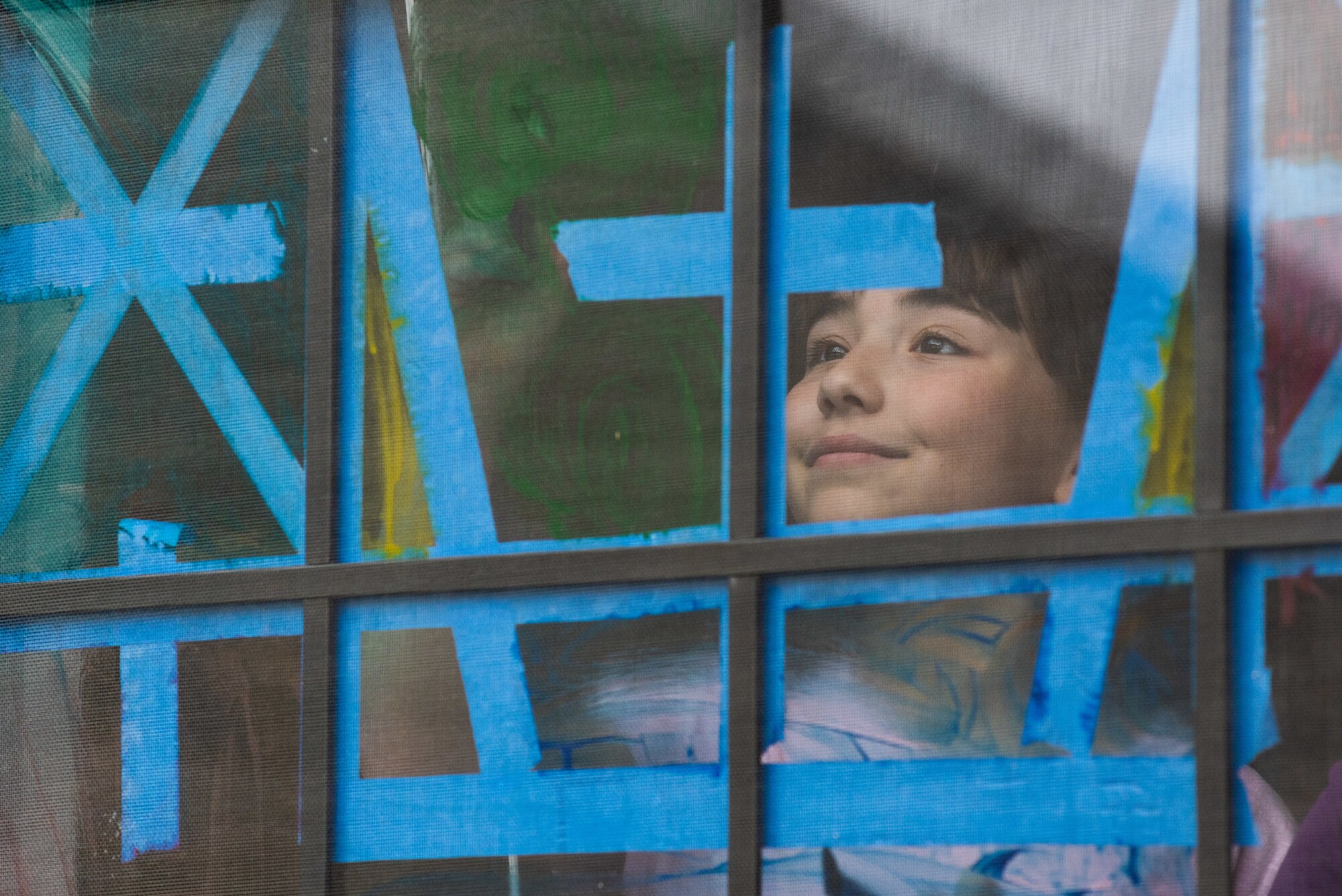 Gracie Carlton, 10, paints a window in her home April 6, 2020, at McConnell Air Force Base, Kansas. April is the Month of the Military Child, in dedication to the resilient children of military members and their bravery on the homefront. Gracie is expressing her creativity while practicing physical distancing by creating art indoors that her community can enjoy when passing by. (U.S. Air Force photo by Staff Sgt. Chris Thornbury)