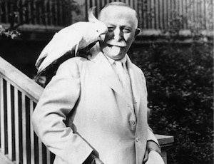 Dr. John H. Kellogg with a cockatoo on his shoulder.