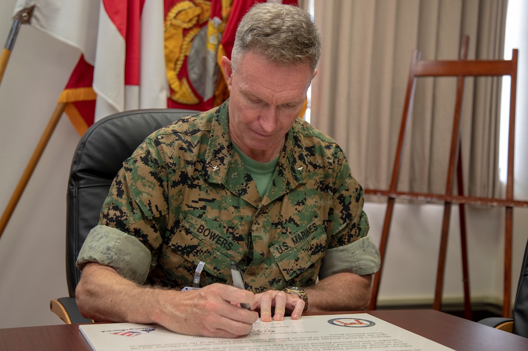 U.S. Marine Corps Brig. Gen. William J. Bowers, commanding general of Marine Corps Installations Pacific-Camp Smedley D. Butler, signs the Military Saves Month proclamation at building one on Camp Foster, Okinawa, Japan March 30.