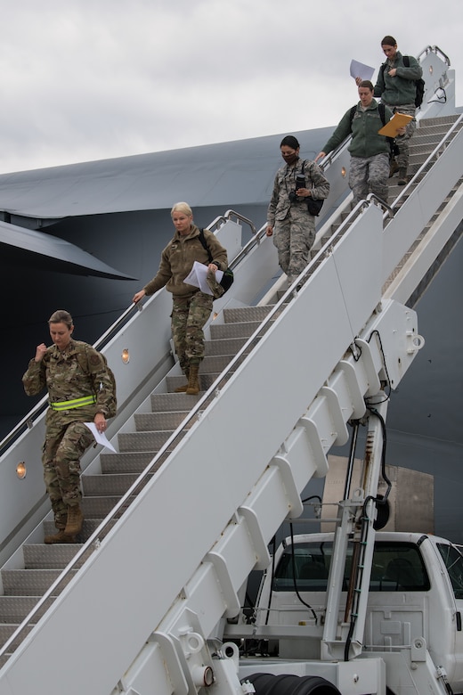Photo of servicemembers departing an aircraft.