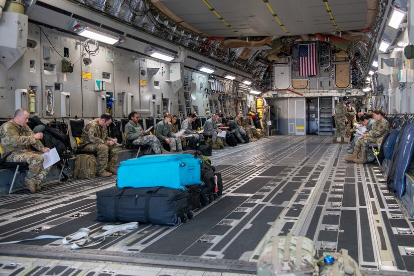 Photo of Airmen sitting inside a C-17 Globemaster.