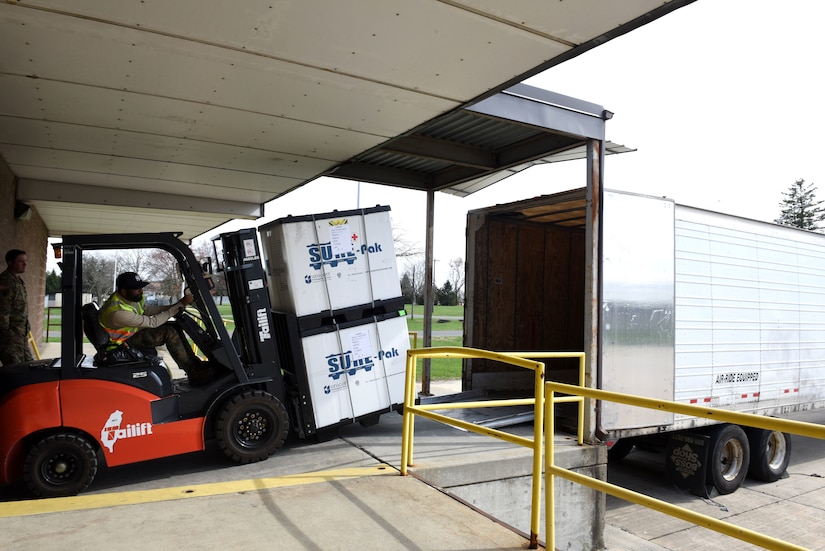 Photo of a forklift loading packages onto a truck.