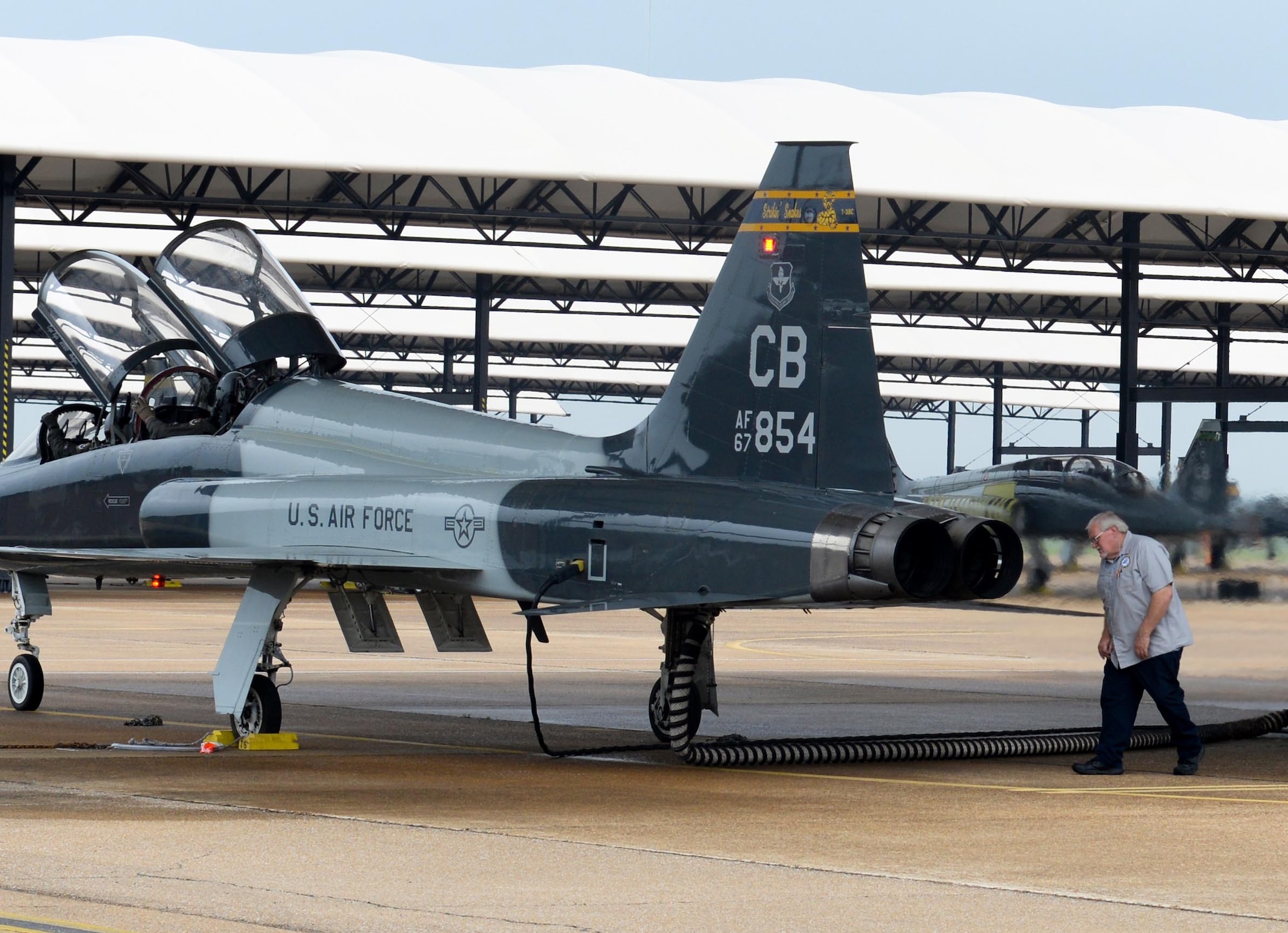 An M1 Support Services maintainer conducts preflight checks on a T-38 Talon, while two 14th Flying Training Wing pilots sit in the cockpit April 8, 2020, at Columbus Air Force Base, Miss. The Air Education and Training Command is the primary user of the T-38 for joint specialized undergraduate pilot training. Pilot training has been deemed essential operations and continues amid the COVID-19 pandemic. (U.S. Air Force photo by Airman 1st Class Davis Donaldson)