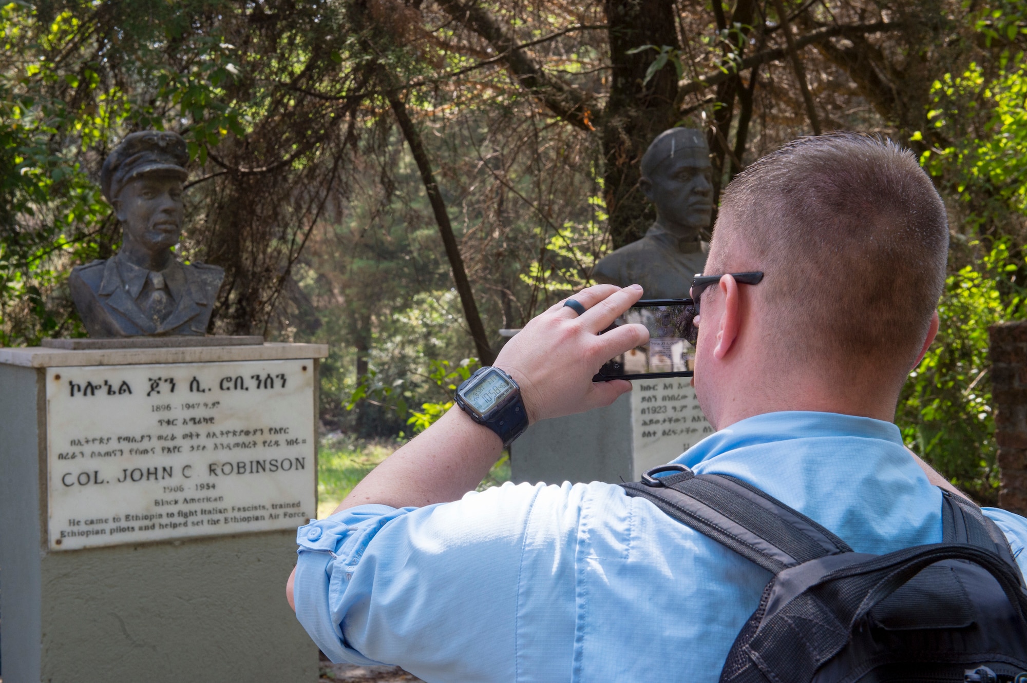 U.S. Air Force Maj. Stephen White, 818th Mobility Support Advisory Squadron maintenance officer air advisor, takes a photo of the final resting place of a legendary African-American aviator at the Addis Ababa War Cemetery in Ethiopia Jan. 11, 2020. The 818th MSAS is comprised of more than 28 Air Force specialties who advise, assist, and train foreign military partners in Africa. (U.S. Air Force photo by Staff Sgt. Sarah Brice)