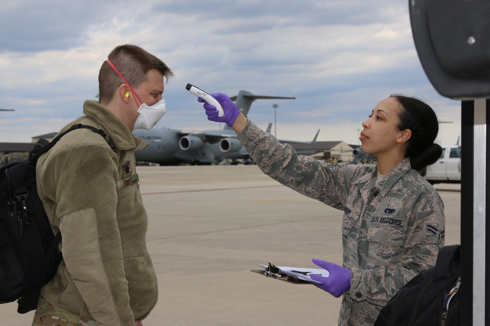 U.S. Air Force service members receive a temperature scan upon arriving at Joint Base McGuire-Dix-Lakehurst as they begin their mission as part of the DoD response to COVID-19, April 5. U.S. Northern Command, through U.S. Army North, is providing military support to the Federal Emergency Management Agency to help communities in need. (U.S. Army photo by Spc. Chafelmer Kroll)