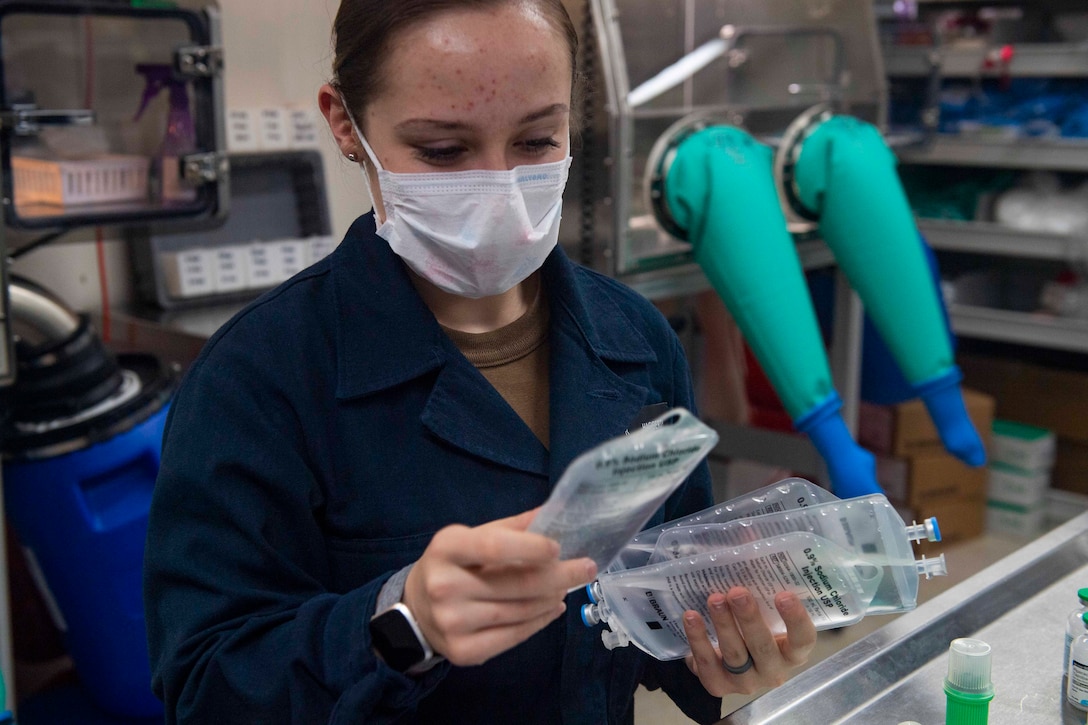 A sailor handles medical supplies.