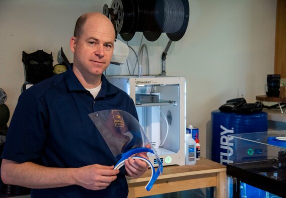 Master Sgt. Justin Pittman, innovaton lab senior project manager, holds a completed face shield April 7,2020, at Dover Air Force Base, Delaware. The face shields were printed by the 436th Airlift Wing Innovation Lab "Bedrock" for use by medical and security forces personnel supporting COVID-19 response efforts. (U.S. Air Force photo by Airman 1st Class Jonathan Harding)