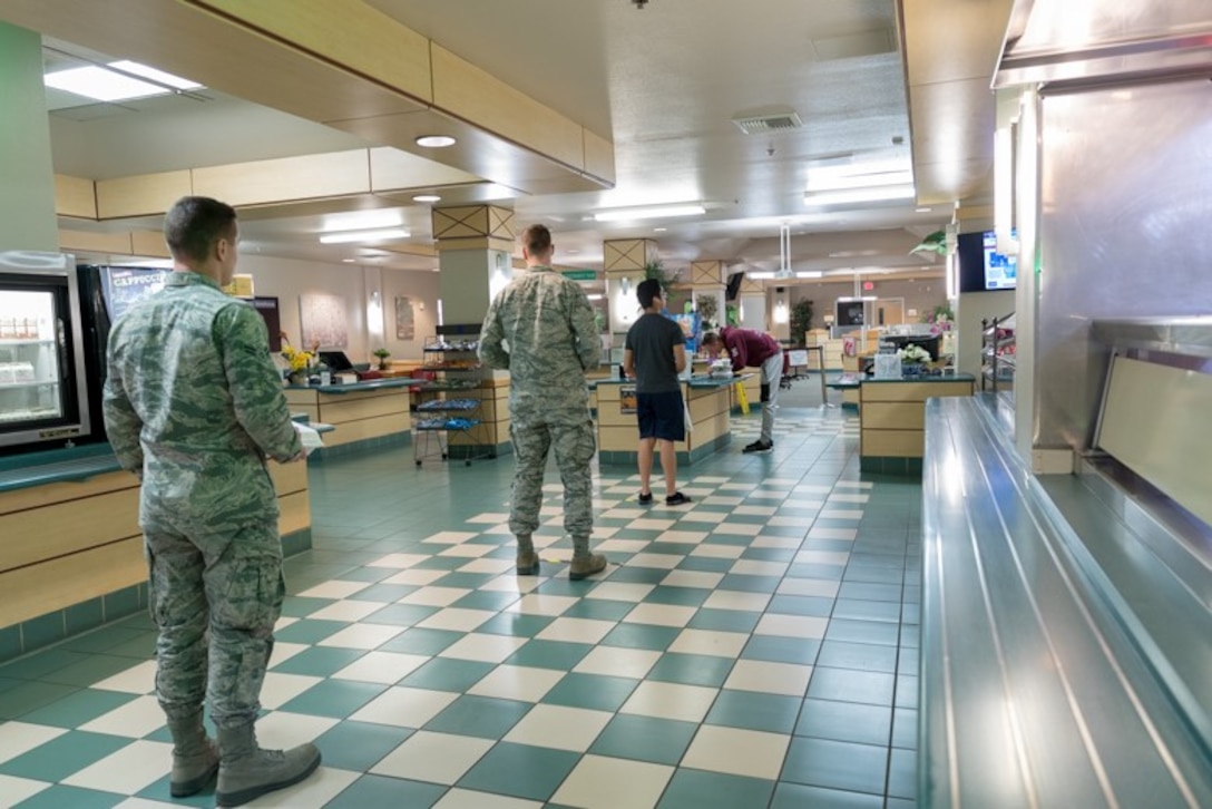 Airmen from Edwards Air Force Base, California, file in line for a meal at the base dining facility maintaining appropriate physical distance, April 7.