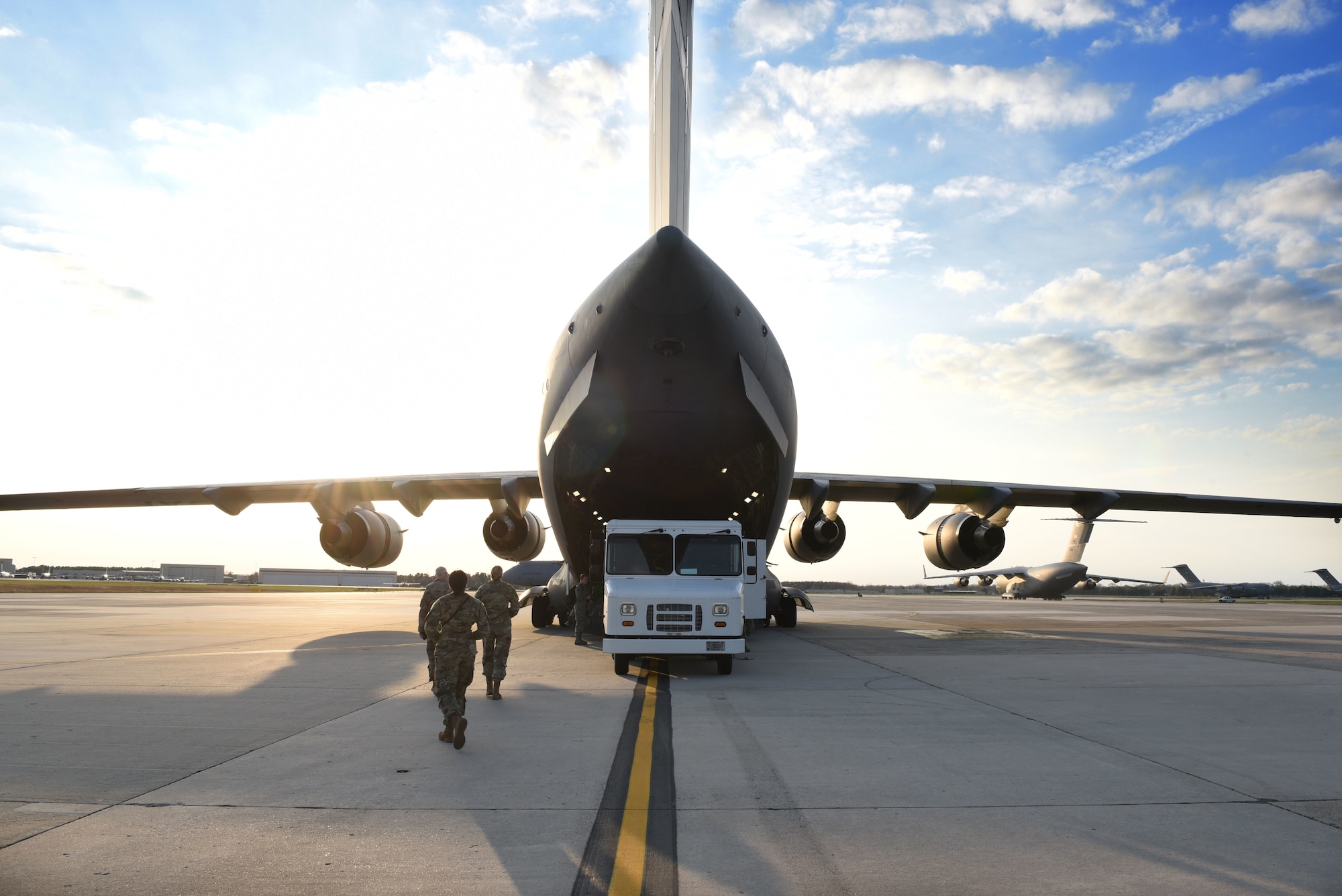 Airmen walk toward a C-17 Globemaster III assigned to Wright-Patterson Air Force Base, Ohio, at Joint Base McGuire-Dix-Lakehurst, N.J., April 5, 2020. The C-17 carried Airmen from Ohio and western Pennsylvania who are in transition to New York City in support of U.S. Northern Command providing military support to help combat the spread of COVID-19. (U.S. Air Force photo by Staff Sgt. Stephanie Serrano)