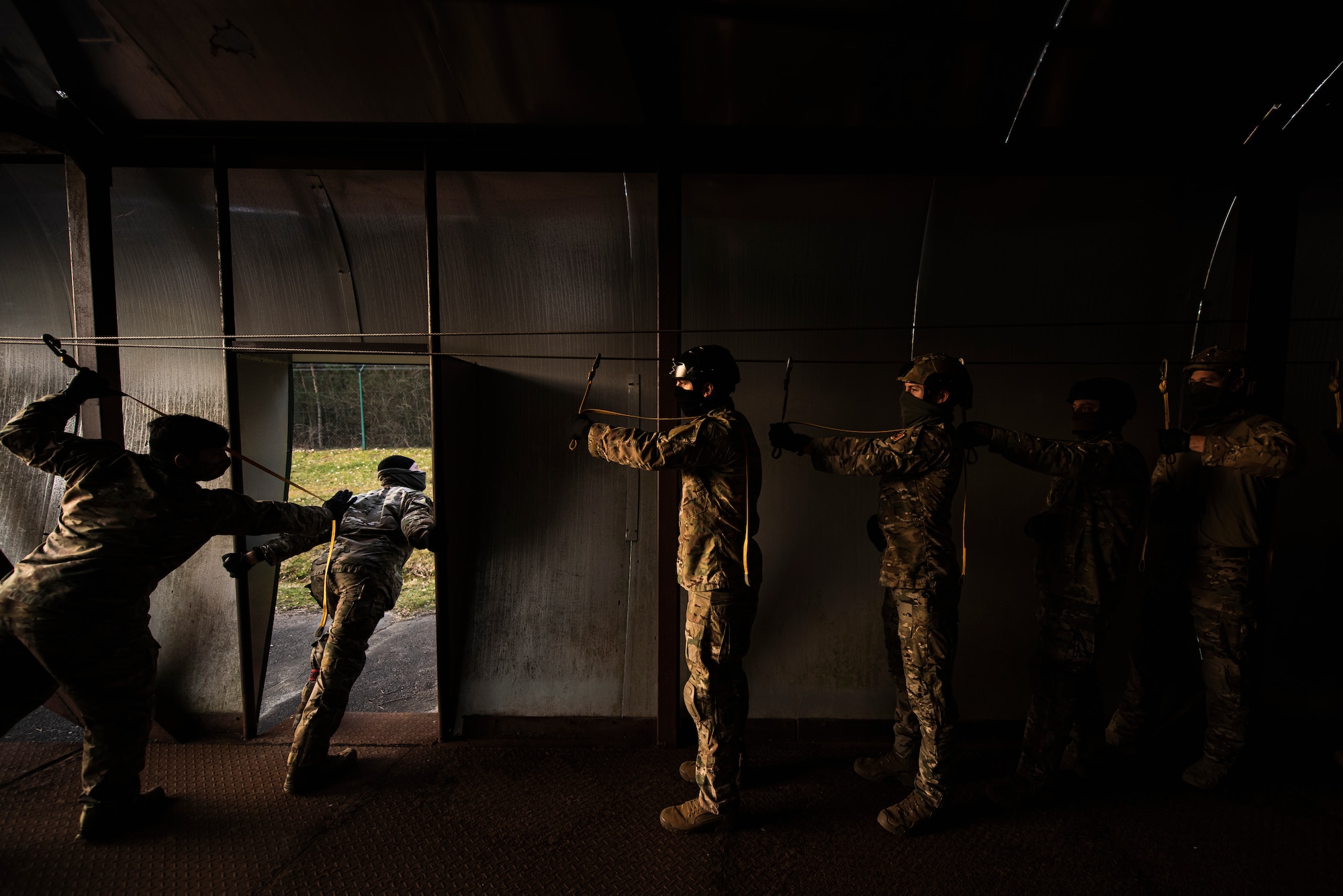 Airmen are standing inside a C-130 training model at sunrise.