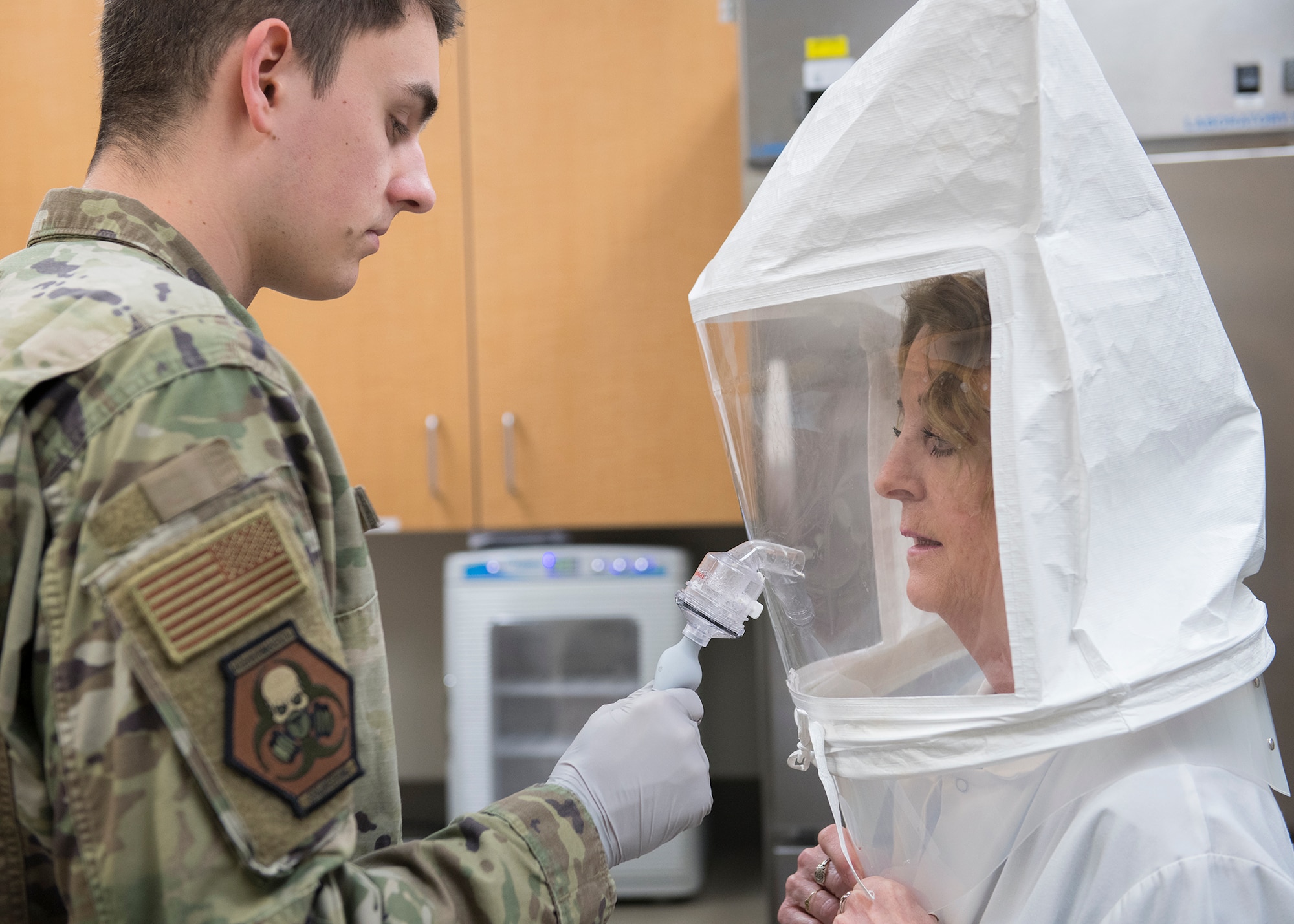 Senior Airman Andrew Hetzler, 56th Bioenvironmental Engineer technician, mists a bitter sensitivity solution in to a qualitative fit test hood worn by Karen St. Aubin, 56th Dental Squadron dental technician, April 1, 2020, at Luke Air Force Base, Ariz.