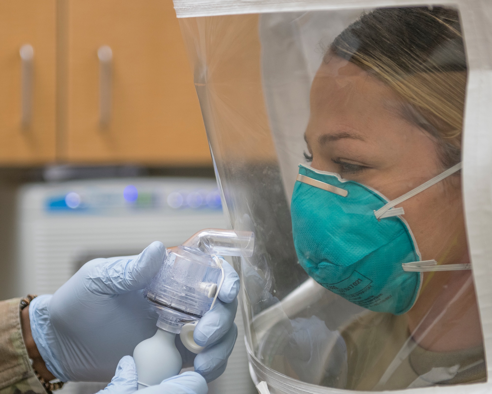U.S. Air Force Staff Sgt. Beth Kenney, 56th Dental Squadron dental assistant, wears a N95 respirator mask while misted with a sensitivity and fit test solution at Luke Air Force Base, Arizona, April 1, 2020. The outer hood isolates the spray, and if the N95 mask is properly fitted, the individual wearing the mask will not smell or taste the solution. Bioenvironmental personnel are fitting masks to protect medical personnel from COVID-19  so they can care for patients. (U.S. Air Force photo by Senior Airman Leala Marquez)