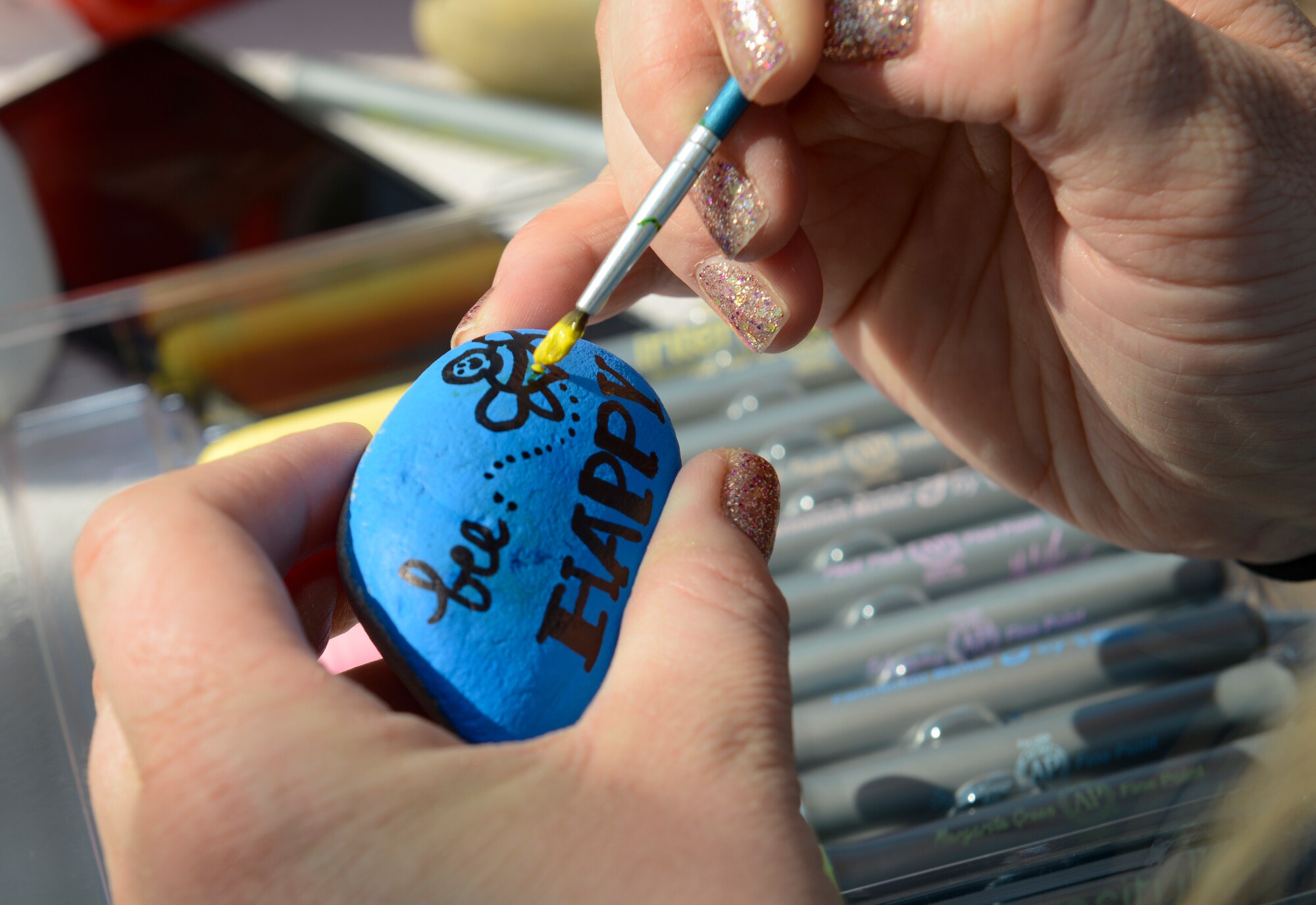 Danyelle Gentry, Ramstein Elementary School front office assistant, paints words of encouragement for the Ramstein community at Ramstein Air Base, Germany, April 7, 2020.