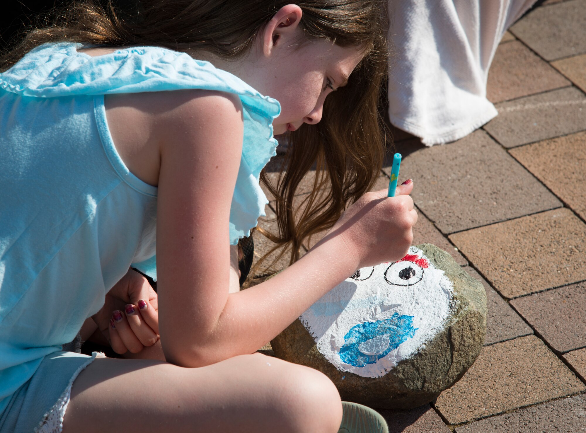 Grace Gentry, Ramstein Intermediate School student, paints a rock to brighten her community at Ramstein Air Base, Germany, April 7, 2020.